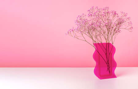 Tender flowers in vase on table over pink banner with copy space for text.
