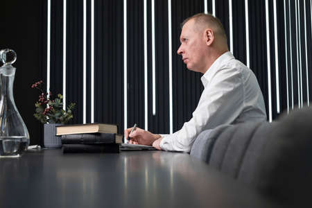 Mature businessman sitting at conference table. Confident man taking part in corporate or strategy...