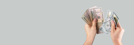 Banner with hands counting US dollar bills on grey background. Income and expenses calculation...