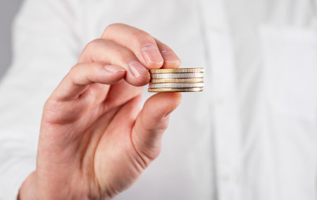 Businessman hand closeup holding coins stack. Money and income concept. High quality photoの写真素材