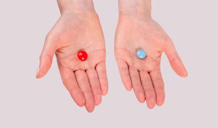 Ð¡hoice between red and blue pills. Woman hands holding tablets. Matrix film. Reality and fantasy concept. High quality photoの写真素材