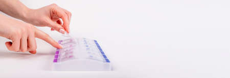 Hands opening pills case, vitamin box. Health care concept. Banner with copy space for text.の写真素材