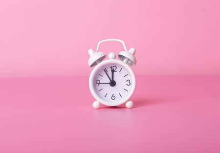 Vintage alarm clock on pink background. Retro modern watches. High quality photoの写真素材