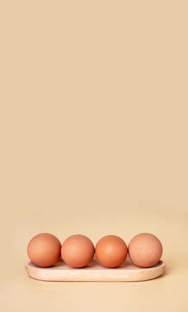 Banner with boiled eggs at wooden server. Easter concept. Copyspace on beige background. Nutritious farm product. High quality photoの写真素材