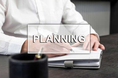 Planning word on photo with hands taking notes in business planner. High quality photoの写真素材