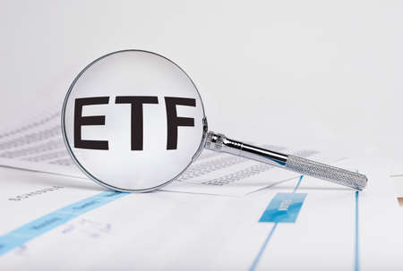 ETF word in magnifying glass. Investment, finance, business and stock market trading concept. Exchange-traded fund. Risks analysis and making money. High quality photoの写真素材