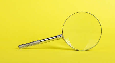 Magnifying glass on yellow background. Information search and analysis, looking for evidence, key words concept. High quality photoの写真素材