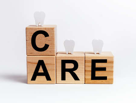Teeth at wooden blocks with word care. Oral hygiene, dental checkup, tooth treatment and whitening, stomatology concept. High quality photoの写真素材