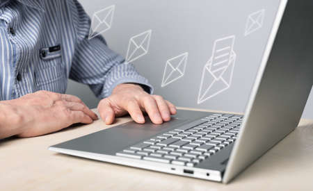 Business mail concept. Man working on laptop and sending letters to partners, colleagues. Online communication. High quality photoの写真素材