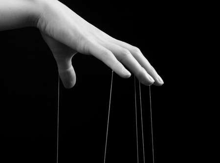 Woman hand with strings on fingers. Manipulation, control concept. Female suffering from blaming,...