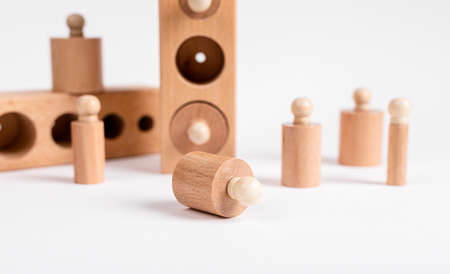 Montessori knobbed wooden cylinders with blocks. Kids puzzle for development of eye hand coordination and concentration. High quality photoの写真素材