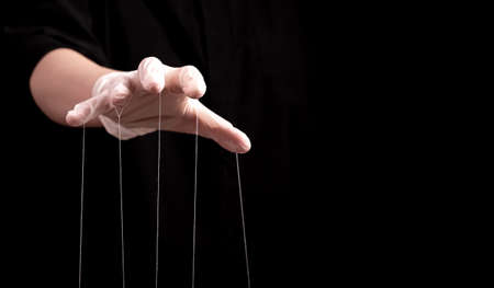 Banner with hand in medical glove with strings on fingers. Deception in medicine and pharmacy, conspiracy theory, health care fraud, negative impact on patient concept. Copy space. High quality photoの写真素材