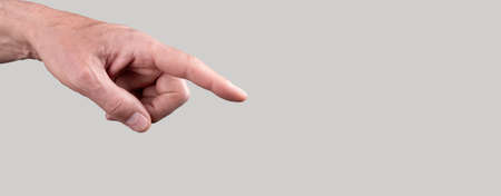 Banner with woman hand with forefinger pointing to object on grey background. Copy space. High quality photoの写真素材