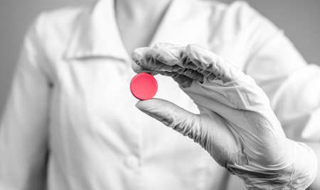 Doctor holding birth control pill or tablet for painful menstruation cramps, menstrual cycle...