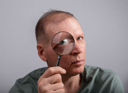 Eye problem, disease concept. Pain, ache and eyesight checking. Woman with magnifying lens. High quality photoの写真素材