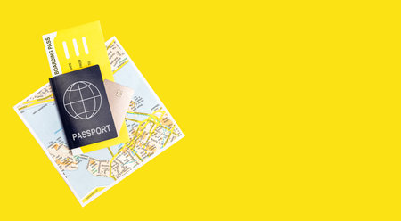 Travelling by air concept. Banner with passport, boarding pass, guide and credit card on yellow background. Going on journey by plane, visiting places of interests. Place for text. High quality photoの写真素材