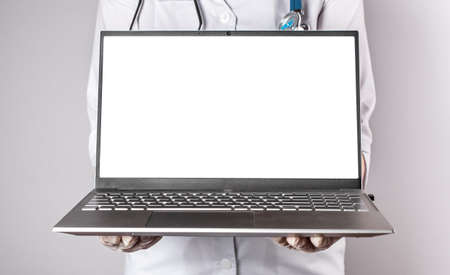 Doctor holding laptop mockup. Online medicine, distant medical consultation to patient, using computer at work and elearning, telehealth concept. High quality photoの写真素材