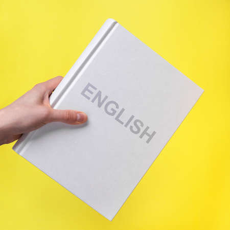 English language book. Hand hold academic literature. High quality photoの写真素材