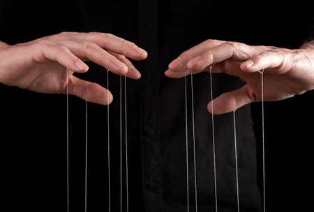 Hand manipulating and controlling smth with strings concept. High quality photoの写真素材