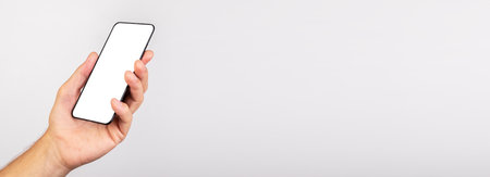 Banner with hand holding phone mockup in angled position. template with empty screen. Using...
