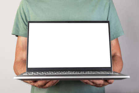 Man holding laptop mockup with empty screen. Male using computer for showing presentation for work, study. Report, new project, startup presentation. high quality photoの写真素材