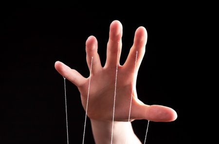 Manipulation, authority concept. Hand with strings controlling, manipulating smth abstract.