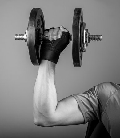 Male arm lifting dumbbell close up. Holding gyms weight for strong biceps. high quality photoの写真素材