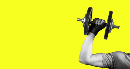 Hand with barbell banner, bright yellow background with copy space. high quality photoの写真素材