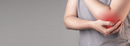 Elbow pain, injury. Cubital trauma, fracture, hurt. Medical banner with copy space for text. High quality photoの写真素材