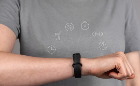 Fitness bracelet on hand, wrist of female athlete close up. Checking activity, functions on smart band, tracker. High quality photoの写真素材