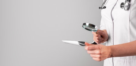 Medical research concept. Doctor hand holding magnifying glass, studying document, scan. Banner, background for text. High quality photoの写真素材