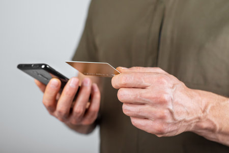 Safety of internet payment, online shopping security concept. Hands paying with bank debit card and mobile phone application, smartphone. High quality photoの写真素材