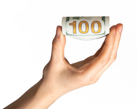 100 dollar bill hand, squeezed between fingers isolated on white background. finance concept.の写真素材
