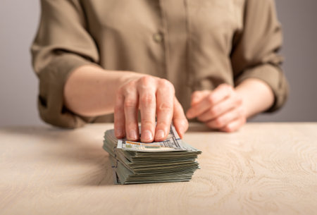 Hand gives money, paying with cash, dollar stack. Payment for big purchase concept.の写真素材