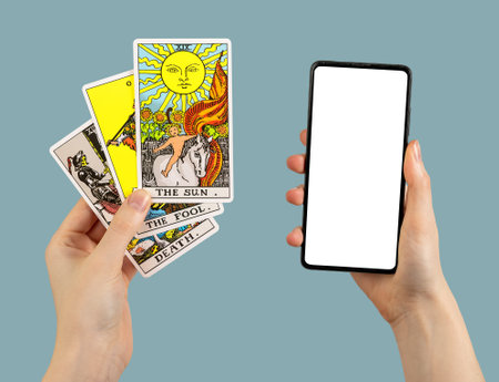 Berlin Germany May 16 2023 Tarot reader, playing cards and mobile smart phone mock up in hand.