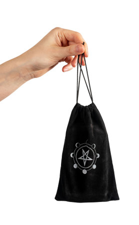 Esoteric magic witch black bag in hand isolated on white.のeditorial素材