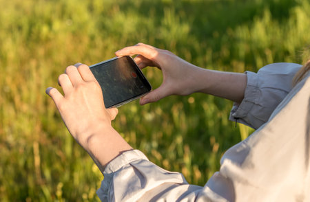 Hands closeup taking photo, recording video of nature landscape on mobile phone.の写真素材