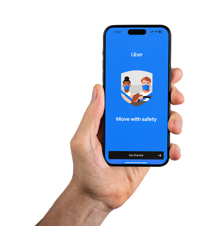 Berlin, Germany July 15 2023 Uber, mobile taxi app on smartphone, isolated on white background.