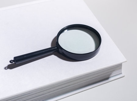 studying, reading books. Research in education with magnifying glass, analyzing data, finding information. University study concept, flat vector isolated on white.の写真素材