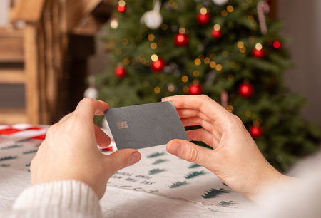 Christmas shopping with credit card. Woman holding online payment gift card. Holiday business pay using mobile, buy commerce. Customer with clean template design. Internetの写真素材