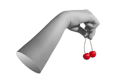 Hand holding sweet summer berries, red cherry twig isolated on white background.の写真素材