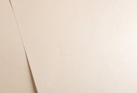 Beige paper texture with soft folds and a smooth, neutral surface. The minimal, abstract design offers a refined, delicate aesthetic, perfect for modern stationery and creativeの写真素材