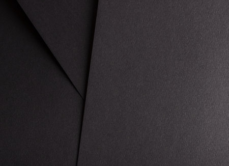 Charcoal black paper background with overlapping layers and a smooth, grainy texture. Bold dark tones and a polished, matte design create a dramatic, refined, and modern composition.の写真素材