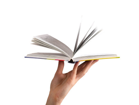 Open book held by hand, flipping pages. Modern hardcover, yellowed paper, symbolizing knowledge, education, and wisdom. Female hand turning page in study, representing history and culture. Isolated onの写真素材