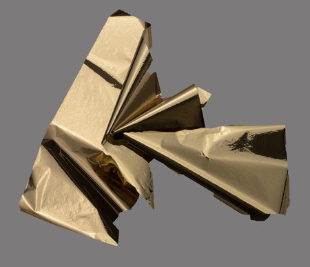 Golden foil folded into sharp, angular geometric shapes creates a modern, abstract design....