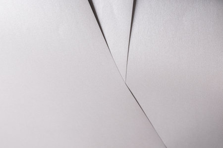 White paper texture with metallic silver and platinum tones, glossy finish and smooth folded surface, modern minimalistic design with clean, sleek composition, creating a luxurious, shiny, and elegantの写真素材