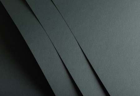Paper texture with dark green tone, layered sheet and punched geometric line overlay, clean matte surface creating stylish elegant backdrop with natural minimalistic style.の写真素材