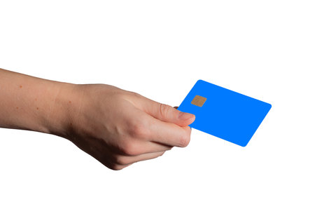 Bank card held in hand with a bright blue and white design, featuring a chip. Customer using the card for secure, cashless payments at the store or ATM. Debit, credit, and loan services with cashbackの写真素材