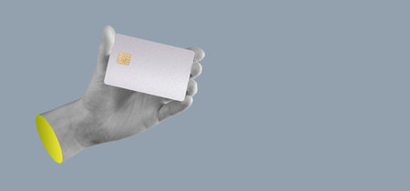 Hand holding a bank card. Modern, elegant design with chip, used for secure online shopping, purchases, and payments. Finance, economy, trade, and cashback concepts. Plastic card for money transfer,の写真素材