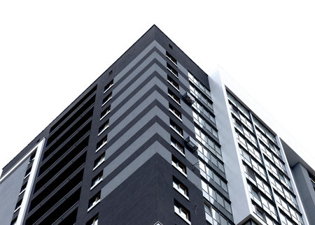 Building corner with modern high rise apartment architecture. Tall white residential structure with geometric facade, clean design and urban real estate development. Isolated on white background.の写真素材